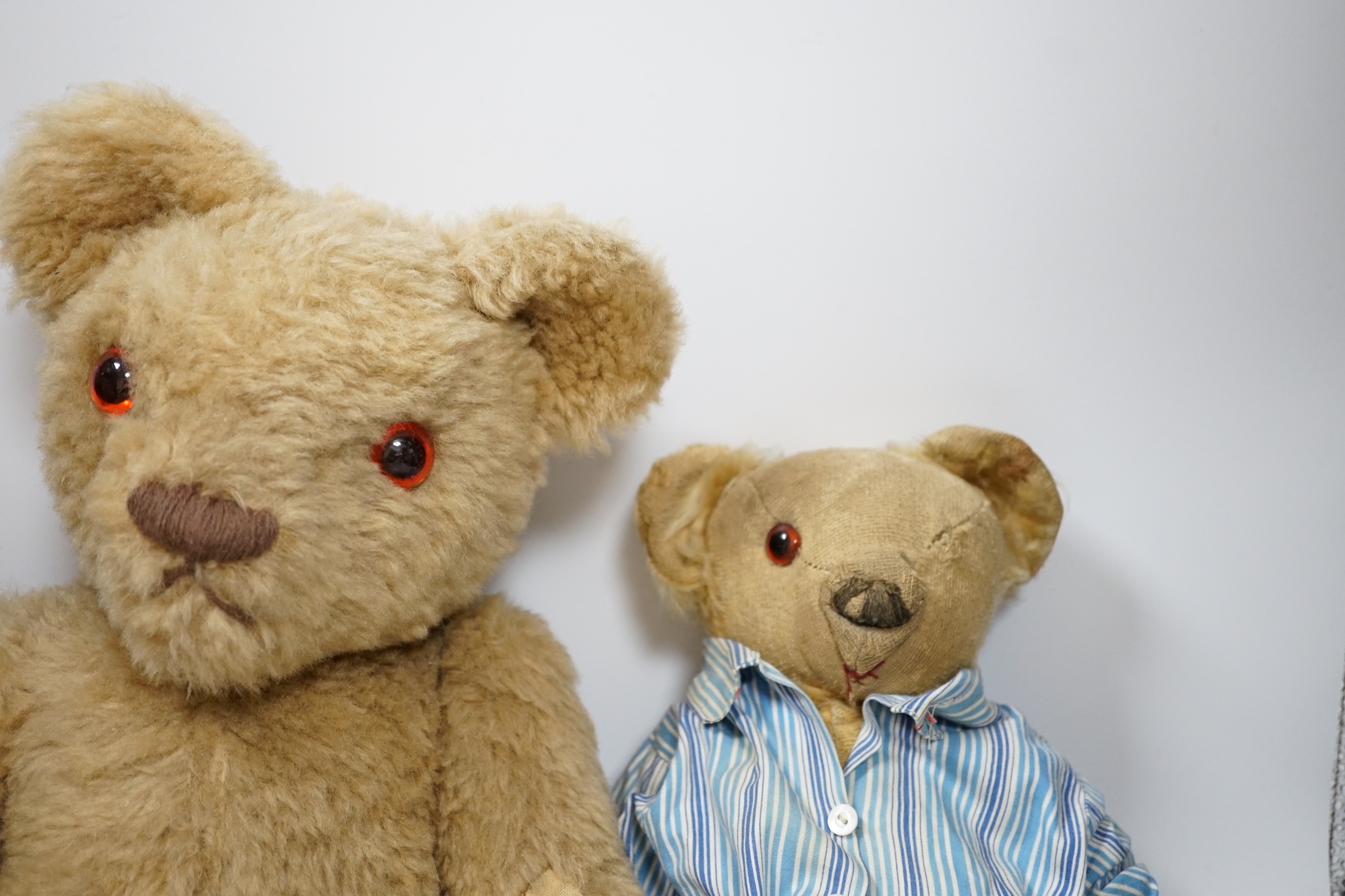 Two Invicta bears, 30cm and 45cm, some wear, and a Merrythought bear, dressed in vintage dressing gown and pyjamas, 32cm high, with hair loss